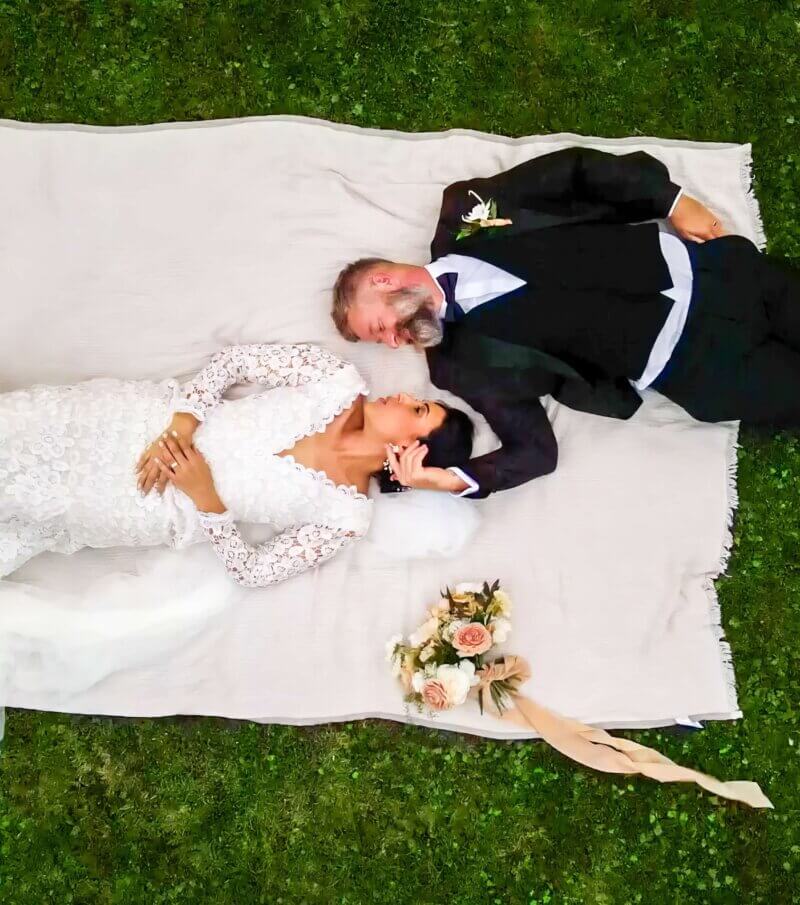 Bride and Groom Lie on blanket